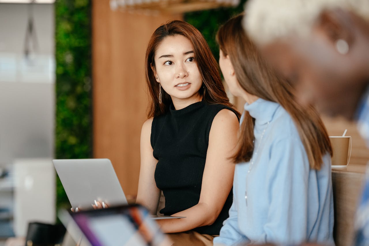 Asian woman discussing business plan with diverse colleagues